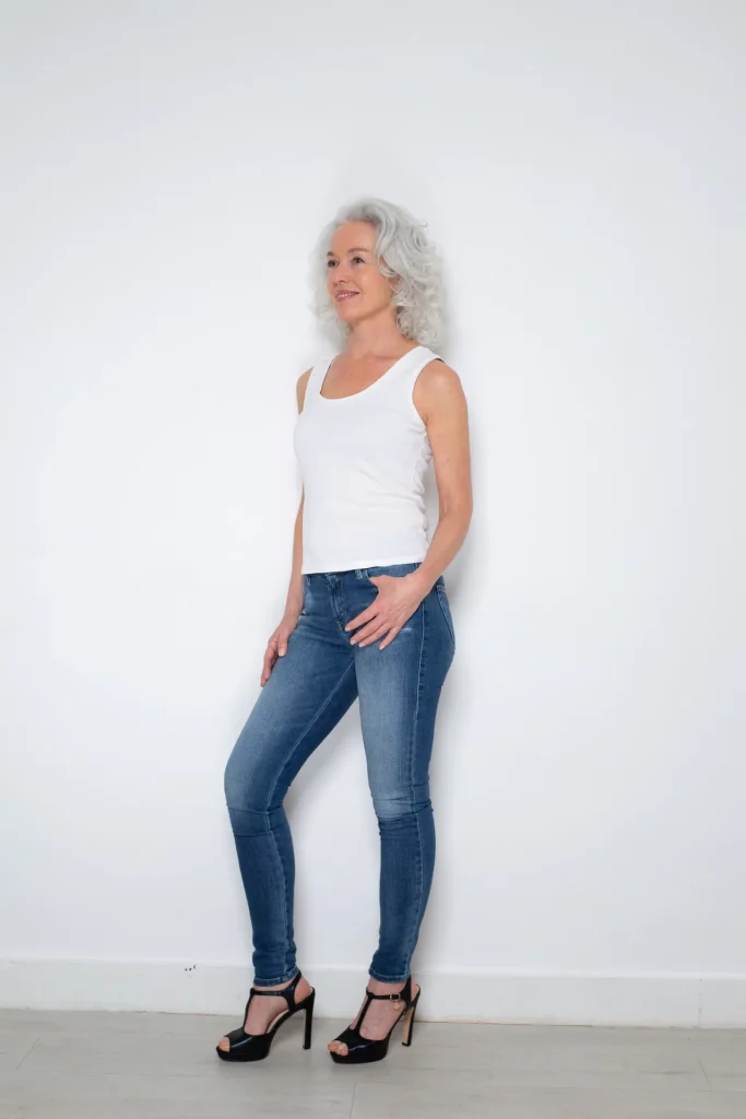 Frau mit grauen Haaren in Jeans und Top