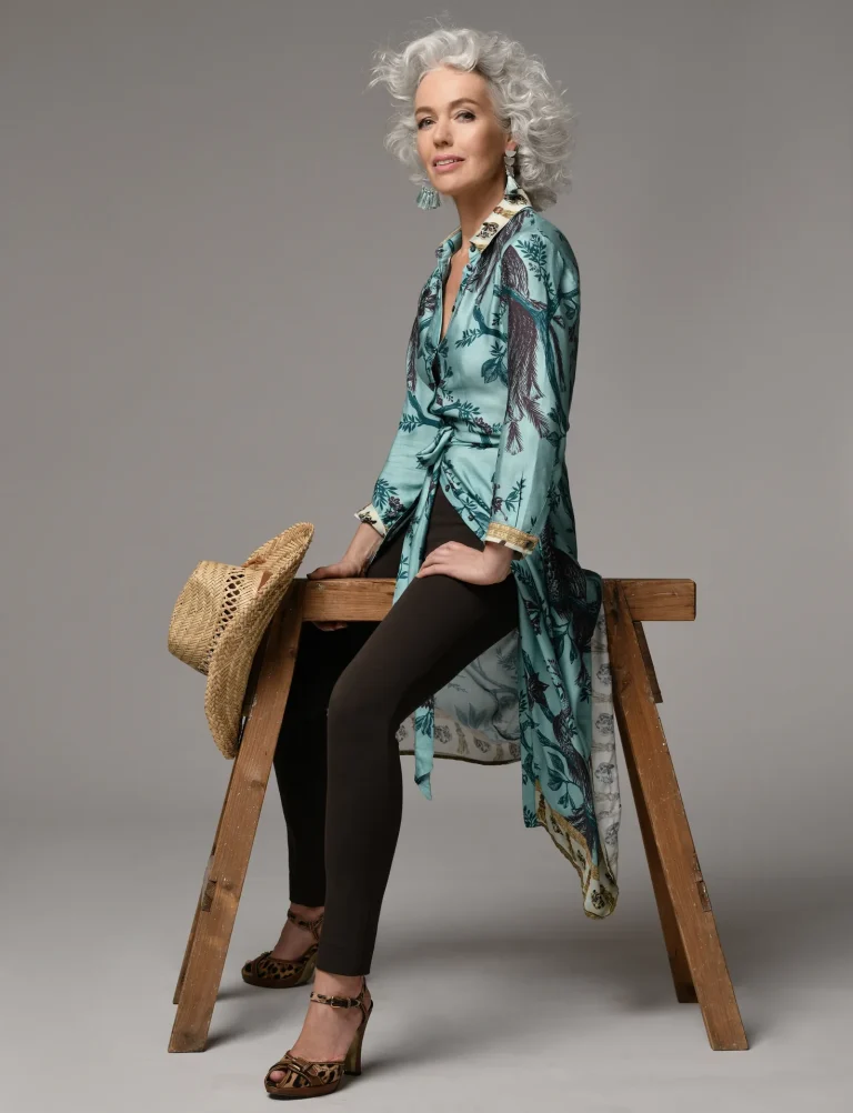 Elegante Frau mit grauen Locken auf Leiter