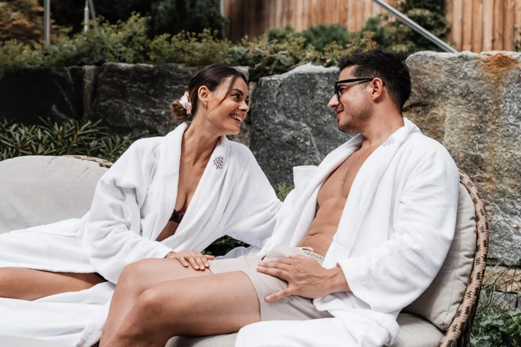 Paar im Bademantel entspannt im Outdoor-Spa