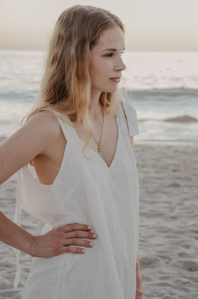 Frau im weißen Kleid am Strand